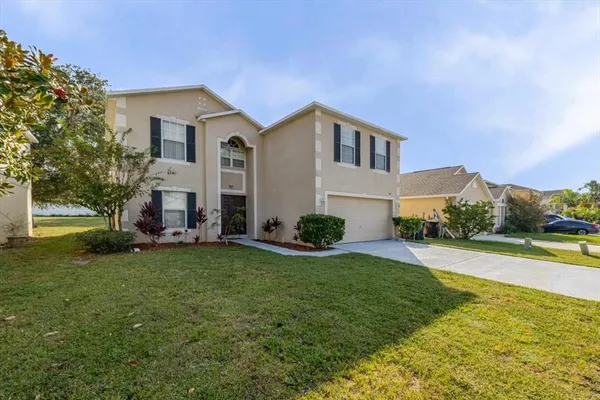 a view of a house with a yard and sitting area