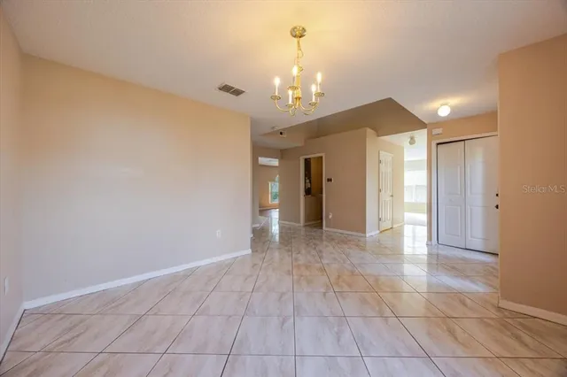 a view of an empty room with a chandelier