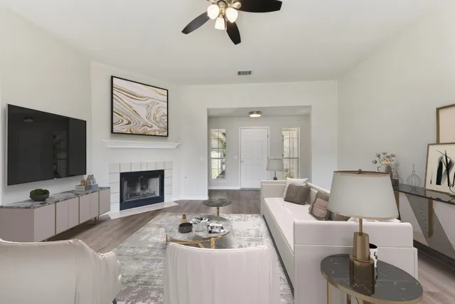 a living room with furniture a flat screen tv and a fireplace