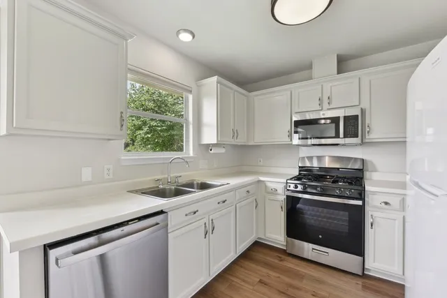 a kitchen with a sink stove top oven and cabinets