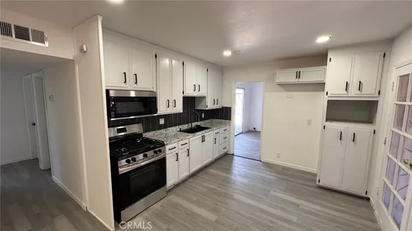 a kitchen with stainless steel appliances kitchen island granite countertop a stove and a refrigerator