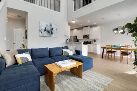 a living room with furniture a rug and kitchen view