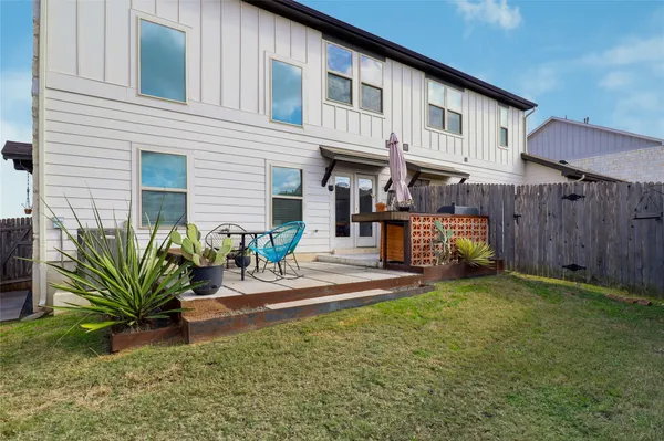 a backyard of a house with table and chairs