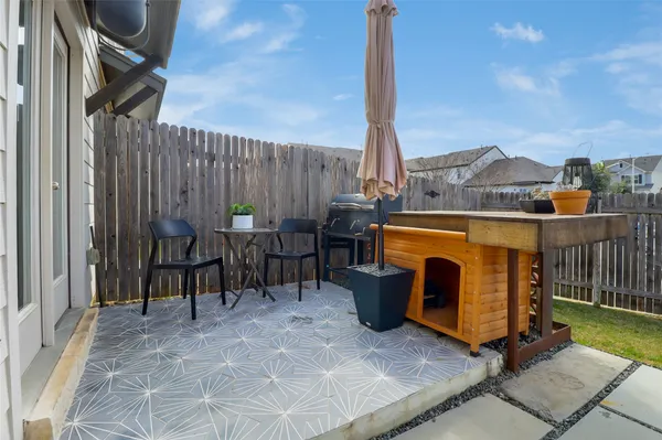 a view of a patio with a table chairs and a grill