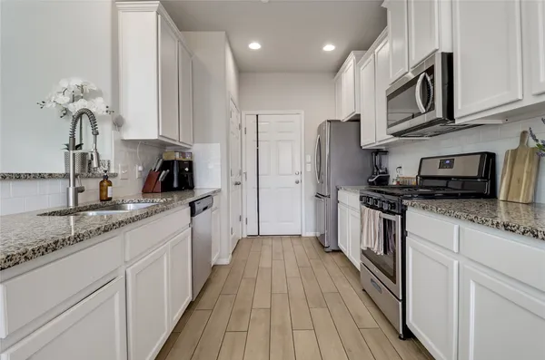 a kitchen with stainless steel appliances granite countertop a sink stove and refrigerator