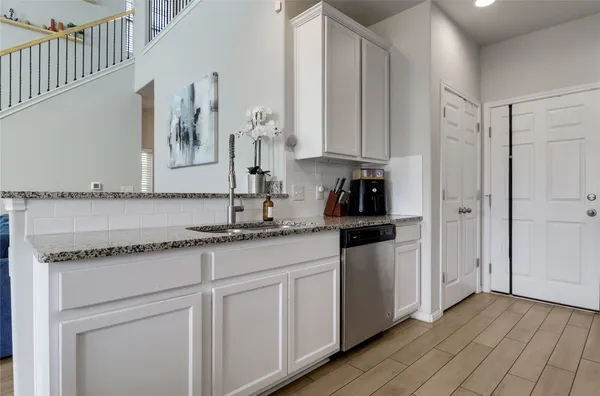 a kitchen with granite countertop a sink and cabinets