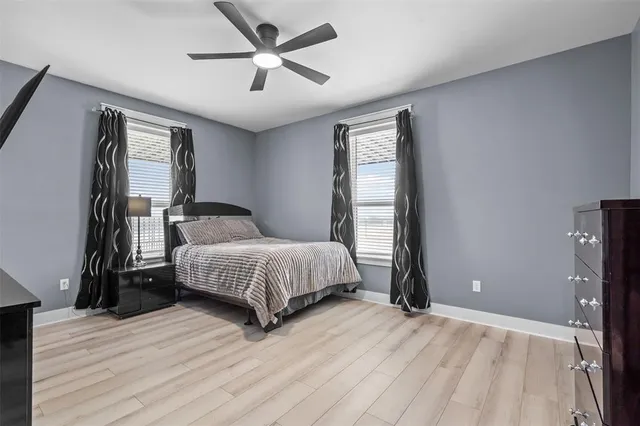 a bedroom with a large bed chandelier and a window