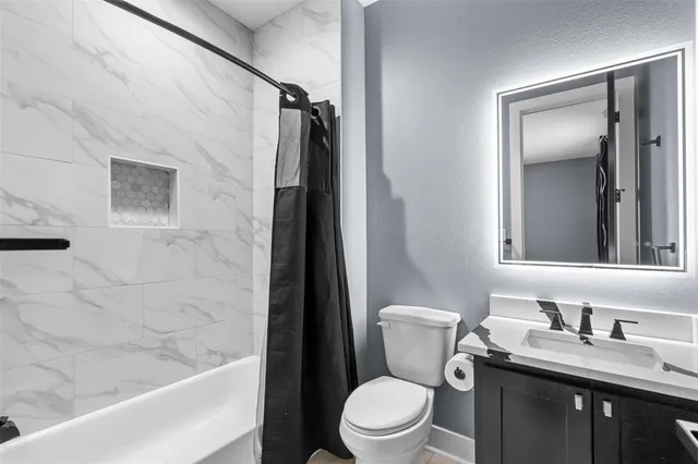 a bathroom with a granite countertop sink toilet and shower