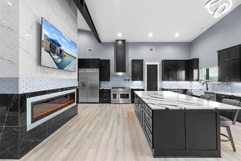 9700 Nix Road Tolar, TX 76476 - Photo 7 of 39 a large kitchen with stainless steel appliances kitchen island granite countertop a stove a sink dishwasher and a microwave oven with large wooden cabinets