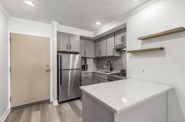 a kitchen with stainless steel appliances a refrigerator sink and stove