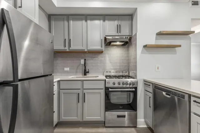 a kitchen with stainless steel appliances a refrigerator sink and cabinets