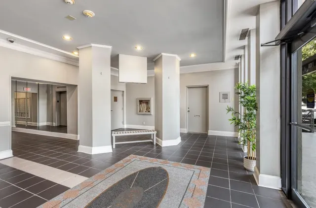 a view of a hallway with wooden floor and a bathroom