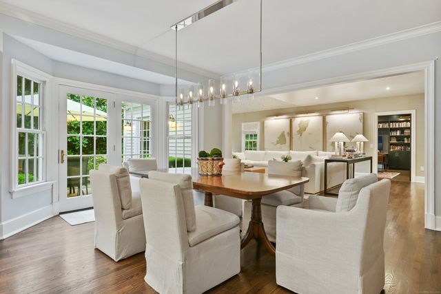 a dining room with furniture a chandelier and wooden floor