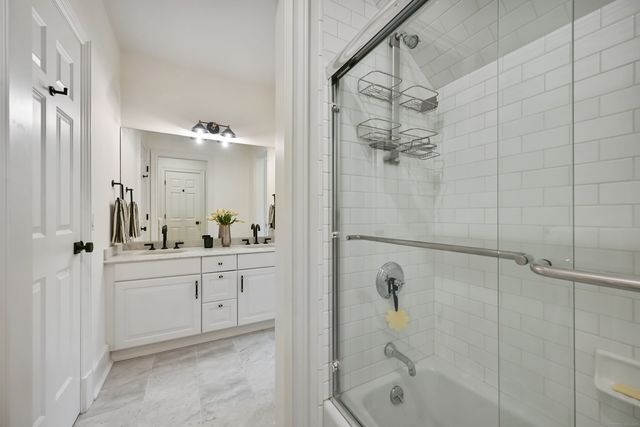 a bathroom with a shower sink and mirror