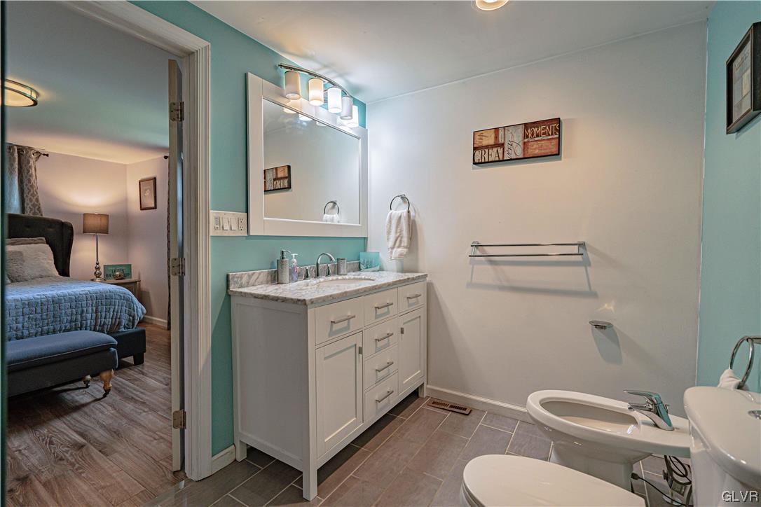 6251 Locust Road Bath, PA 18014 - Photo 27 of 42 a bathroom with a granite countertop toilet sink and a mirror