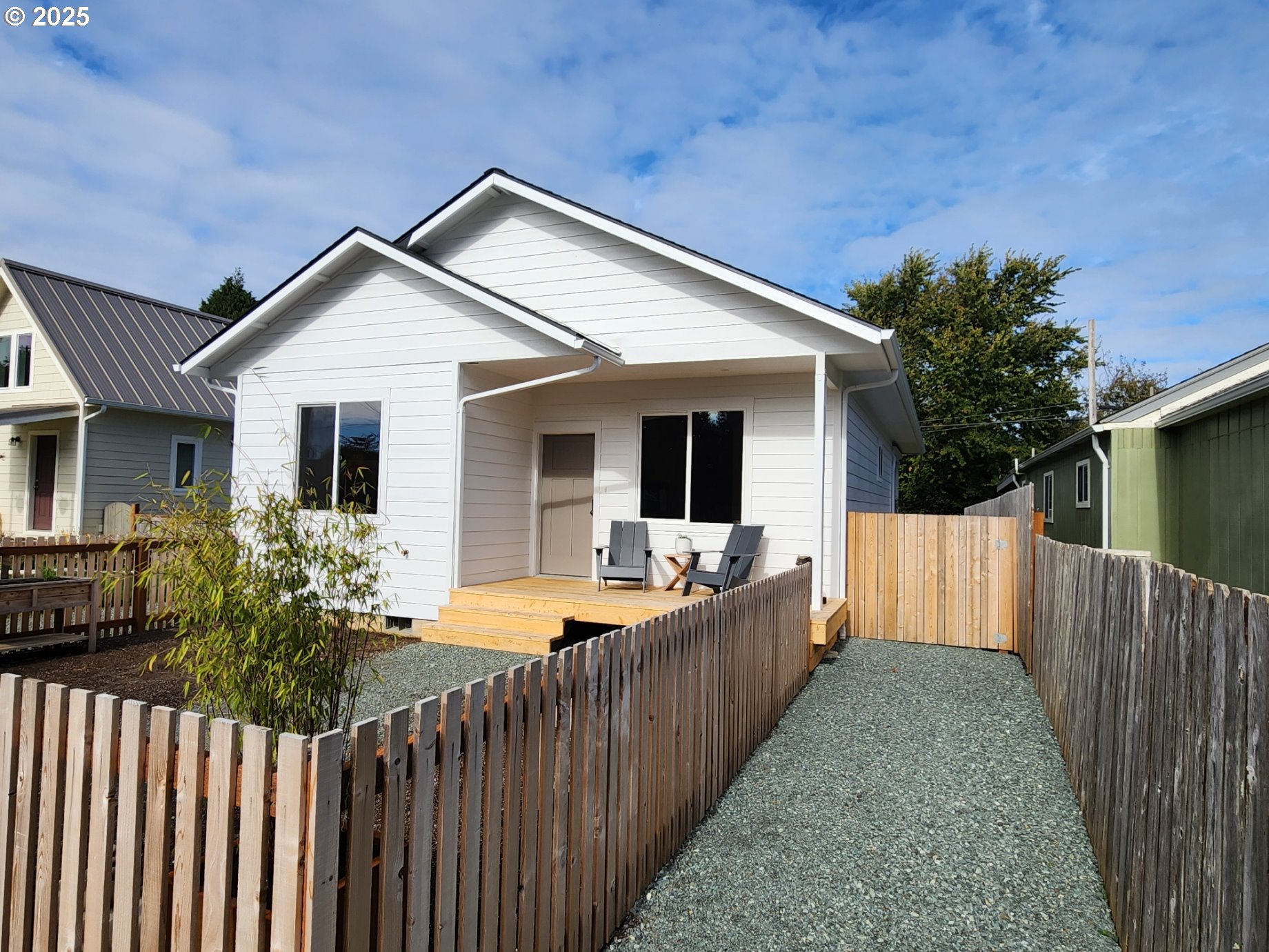 front view of a house with wooden fence next to a small yard