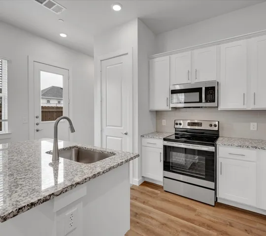a kitchen with granite countertop a stove and a sink