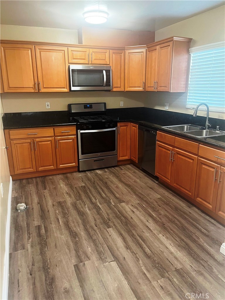 1915-1917 South Orange Drive Los Angeles, CA 90016 - Photo 3 of 11 a kitchen with stainless steel appliances granite countertop a stove a sink and a microwave