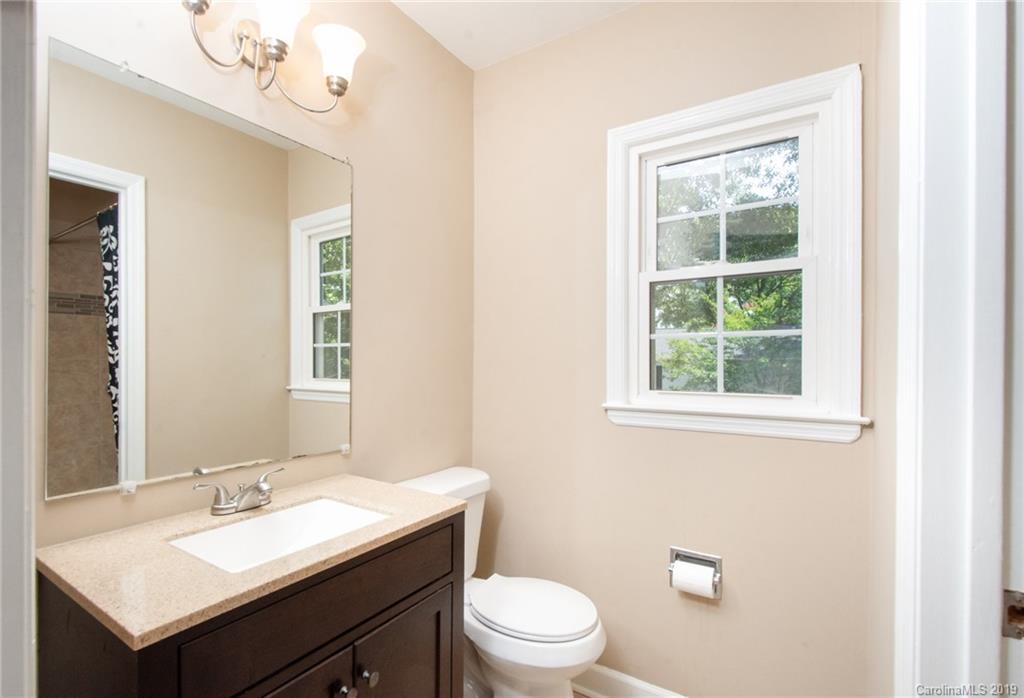 5941 Quail Hollow Road, Unit A Charlotte, NC 28210 - Photo 21 of 26 a bathroom with a granite countertop sink a toilet and a mirror