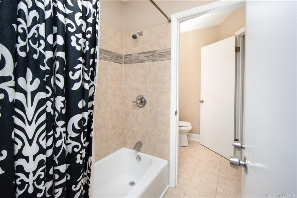 5941 Quail Hollow Road, Unit A Charlotte, NC 28210 - Photo 22 of 26 a bathroom with a bathtub and a shower