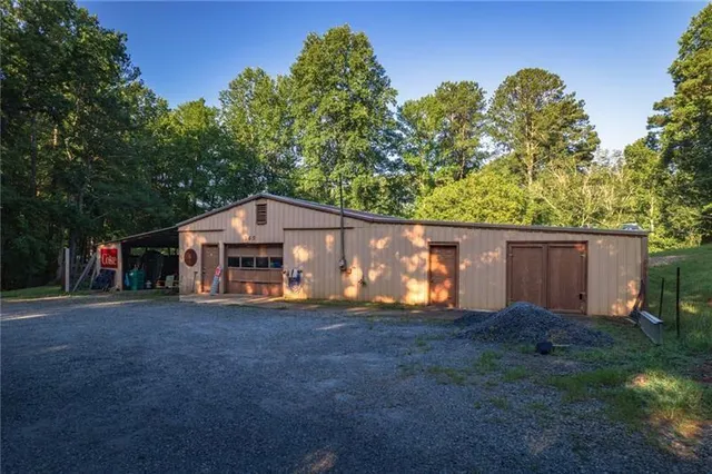 an aerial view of residential house with outdoor space and trees all around