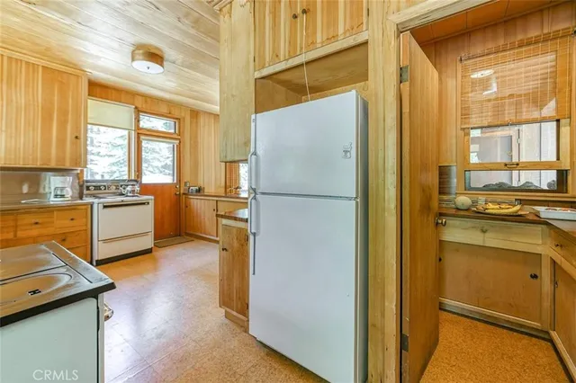 a kitchen with a refrigerator and a stove top oven