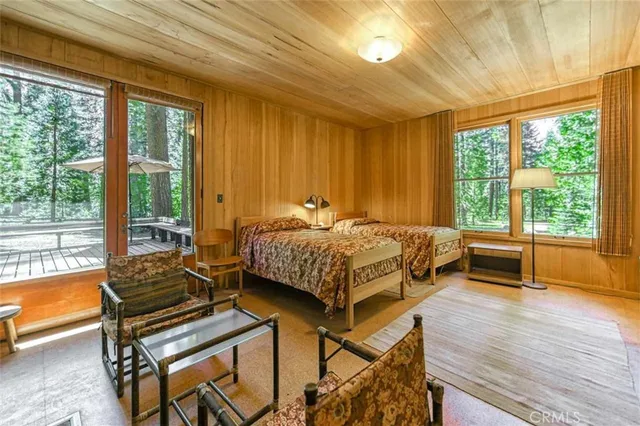 a bedroom with a bed and a large window with outer view