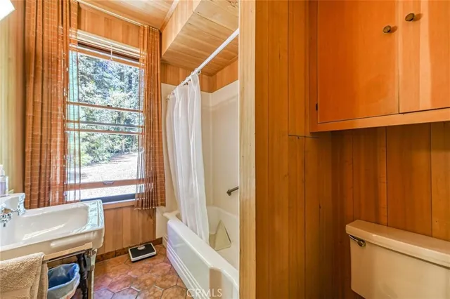 a bath room with a toilet a bath tub and a shower