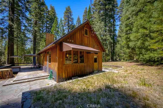 a view of a house with backyard and trees