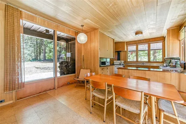 a dining hall with stainless steel appliances granite countertop a stove and a dining table with large windows