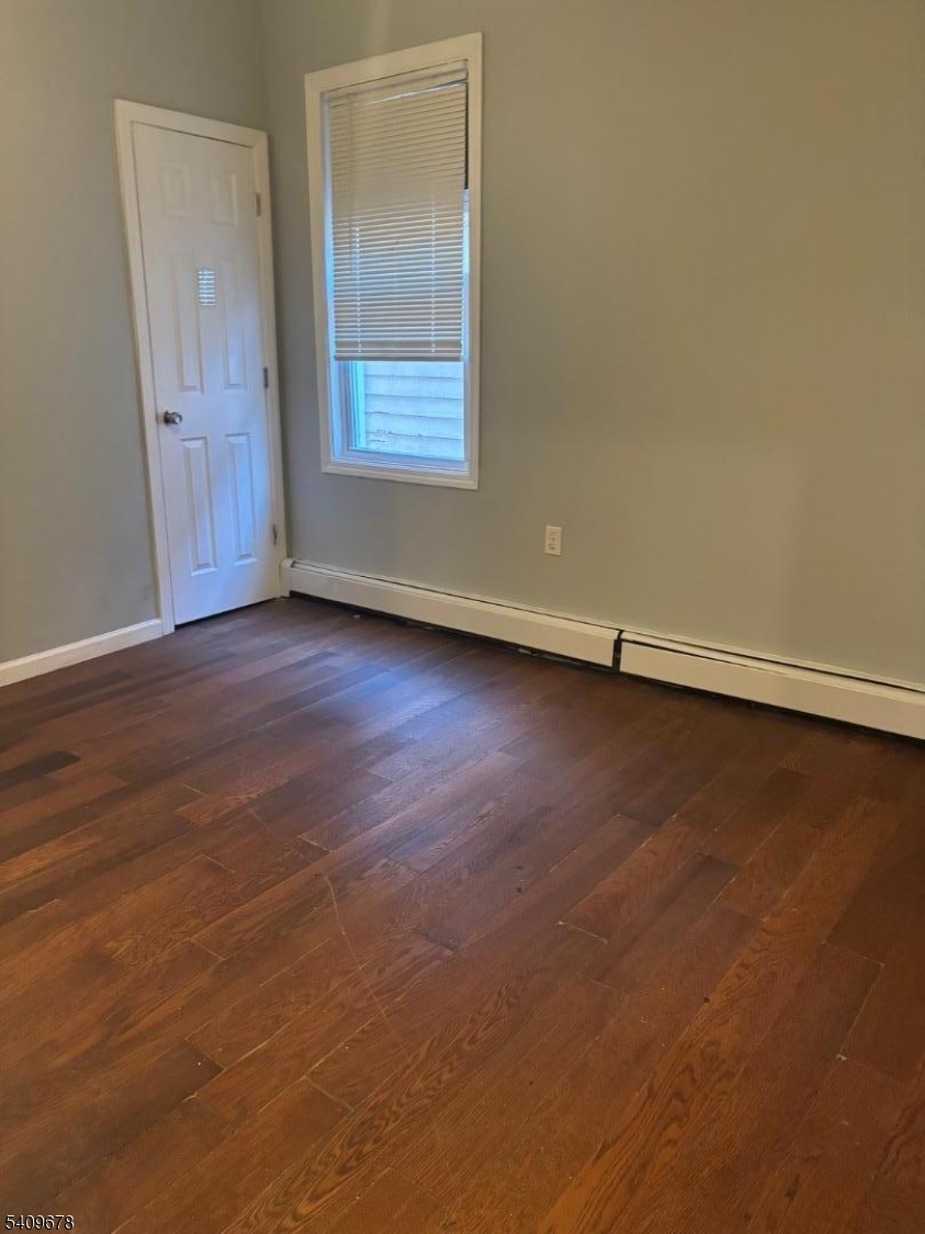 309 South 11th Street, Unit 2 Newark, NJ 07103 - Photo 8 of 13 an empty room with wooden floor and windows