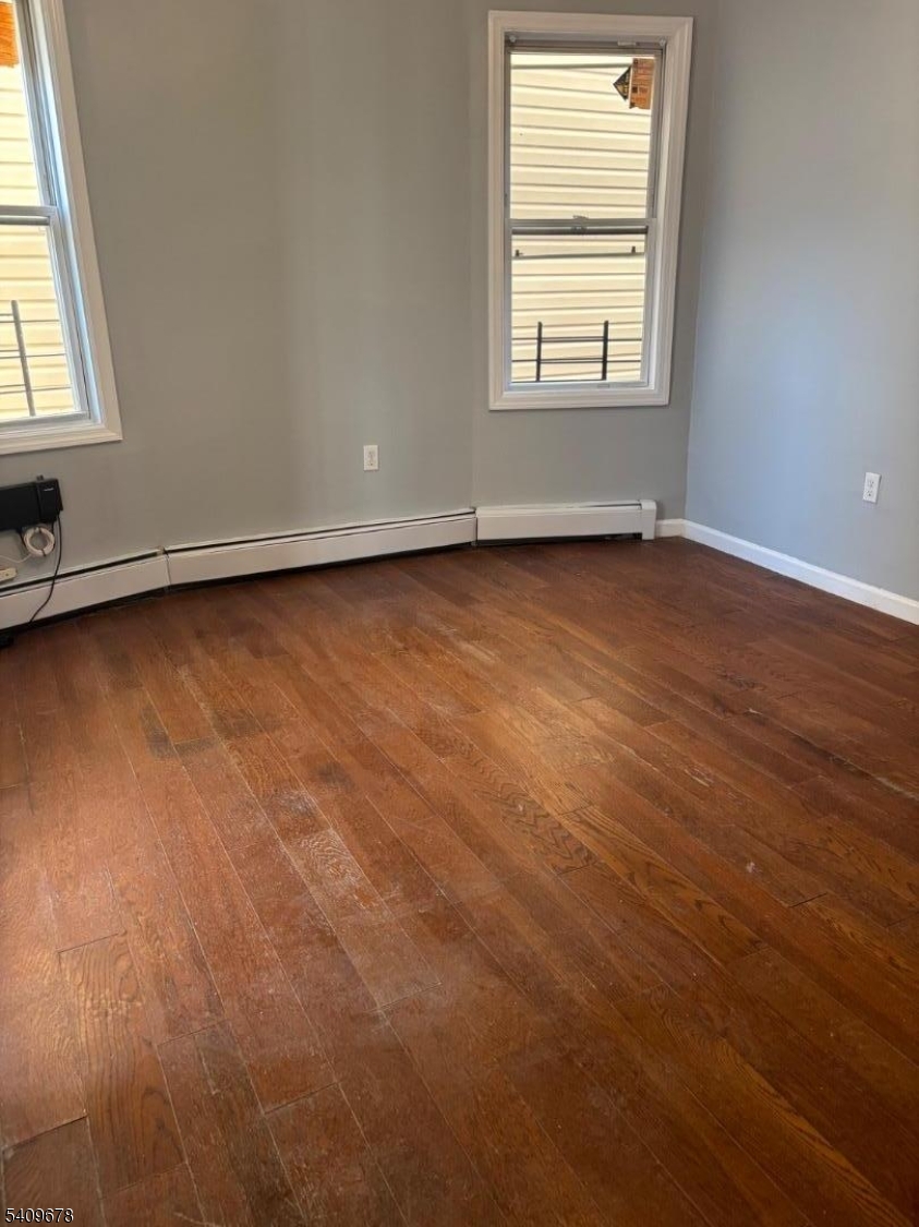 309 South 11th Street, Unit 2 Newark, NJ 07103 - Photo 10 of 13 an empty room with wooden floor and windows