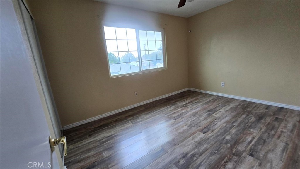 308 North Millard Avenue, Unit 312 Rialto, CA 92376 - Photo 12 of 16 an empty room with wooden floor and windows