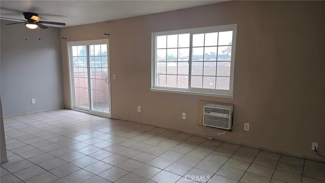 an empty room with windows and fan
