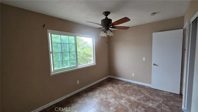 a view of a big room with a ceiling fan and a window