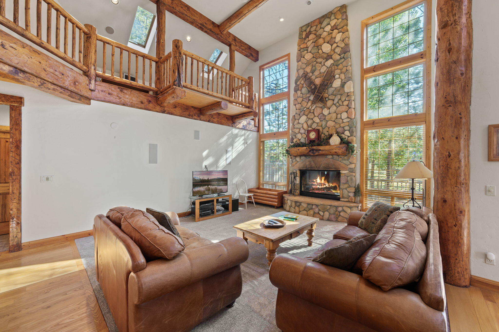 58026 Kinglet Road Sunriver, OR 97707 - Photo 5 of 39 a living room with furniture a fireplace and a large window
