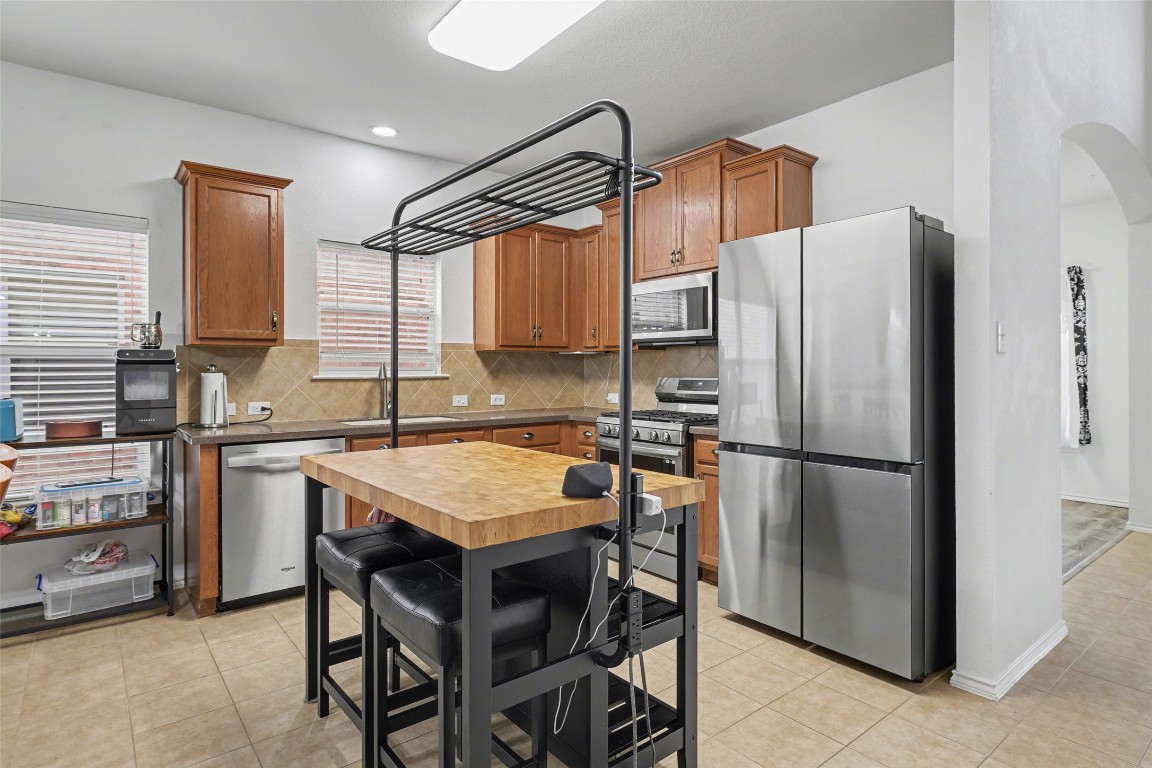 1520 Tonia Loop Round Rock, TX 78665 - Photo 7 of 32 a kitchen with a refrigerator a table and chairs