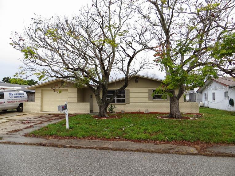 7305 Robstown Drive Port Richey, FL 34668 - Photo 1 of 1 a front view of a house with a yard and garage
