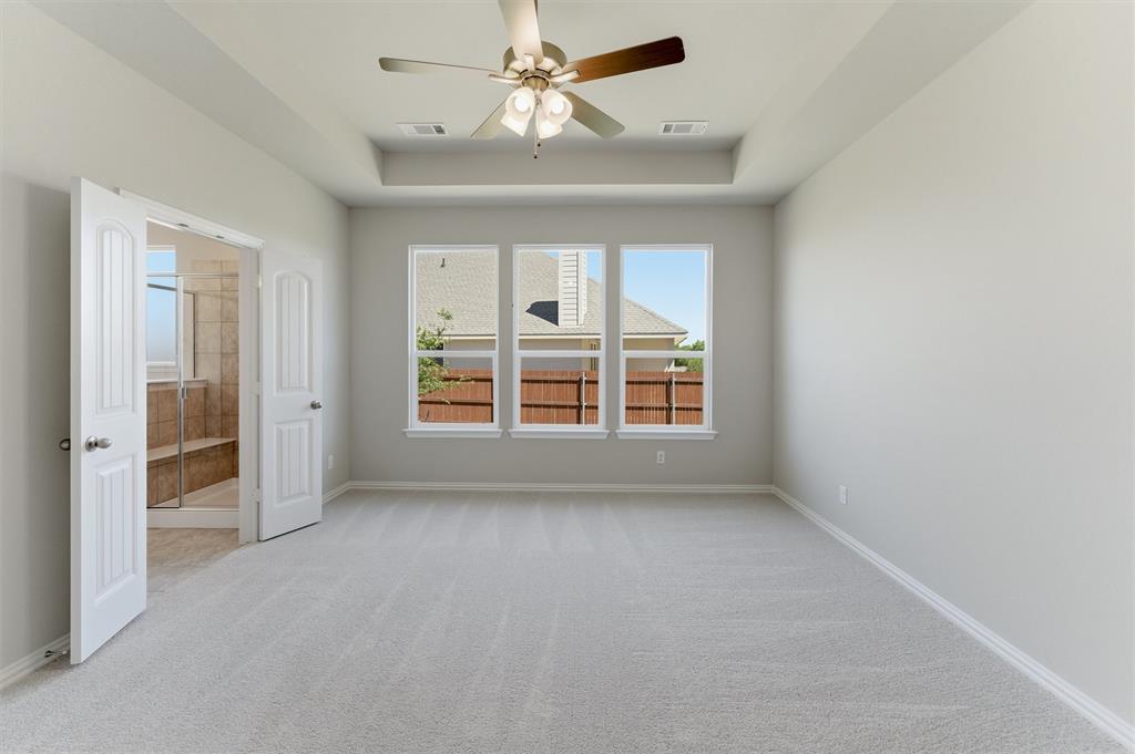 1225 Sabine River Lane Springtown, TX 76082 - Photo 14 of 25 Spare room with ceiling fan, light carpet, and a tray ceiling
