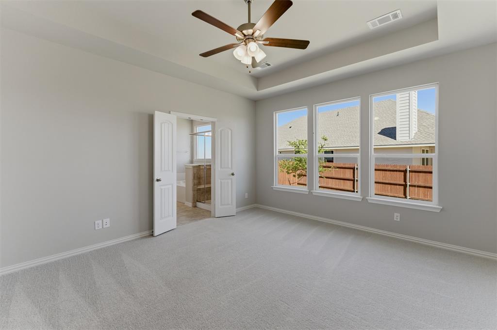 1225 Sabine River Lane Springtown, TX 76082 - Photo 15 of 25 Empty room with light carpet, a raised ceiling, and ceiling fan