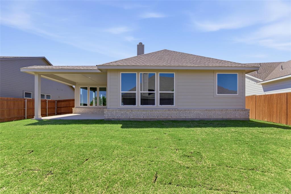 1225 Sabine River Lane Springtown, TX 76082 - Photo 22 of 25 Rear view of house featuring a fenced backyard, a patio area, a shingled roof, and a chimney