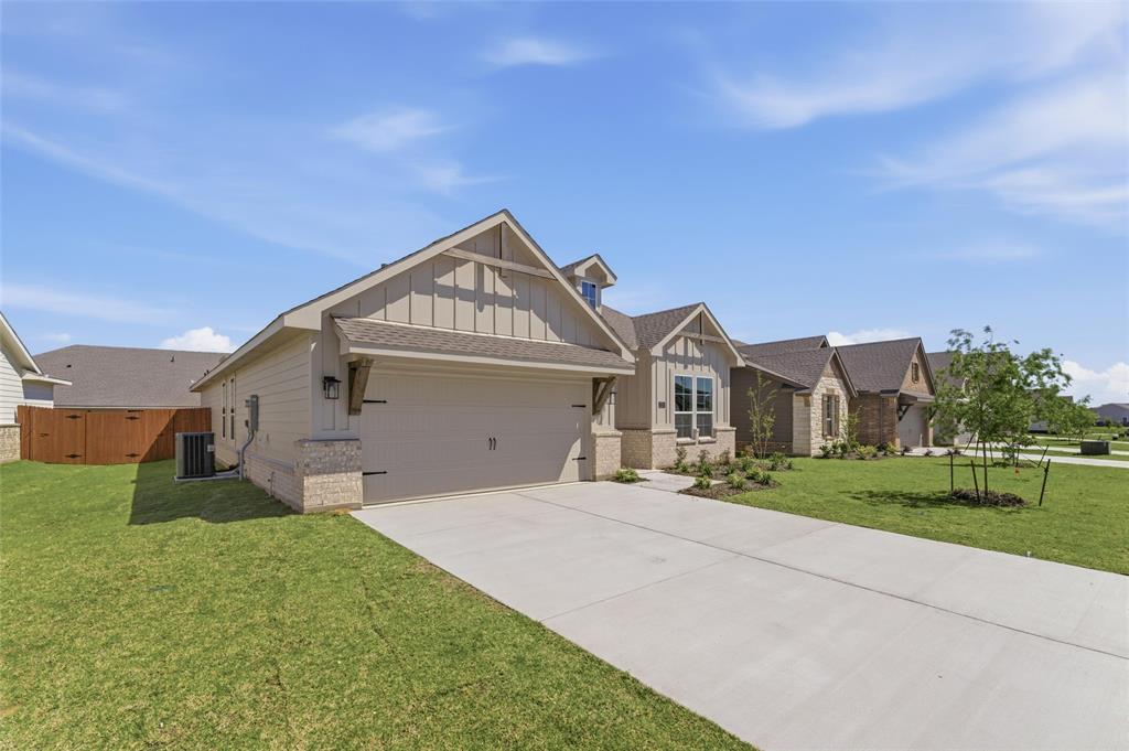 1225 Sabine River Lane Springtown, TX 76082 - Photo 4 of 25 Craftsman house with board and batten siding, brick siding, a garage, driveway, and a front lawn