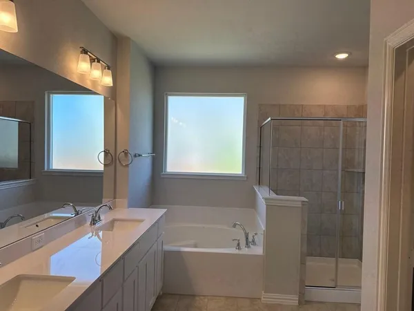 a bathroom with a tub sink and mirror
