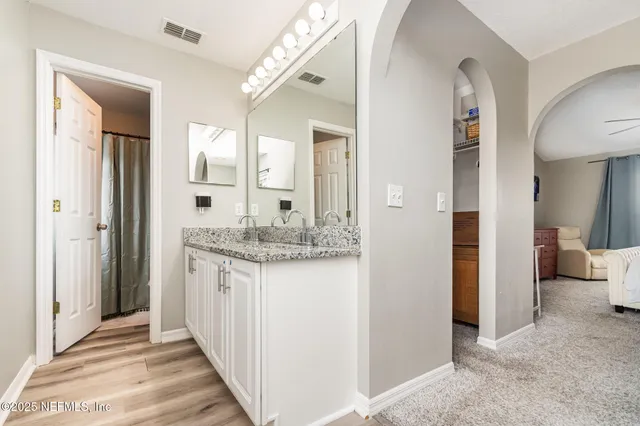 a bathroom with a granite countertop sink and a mirror