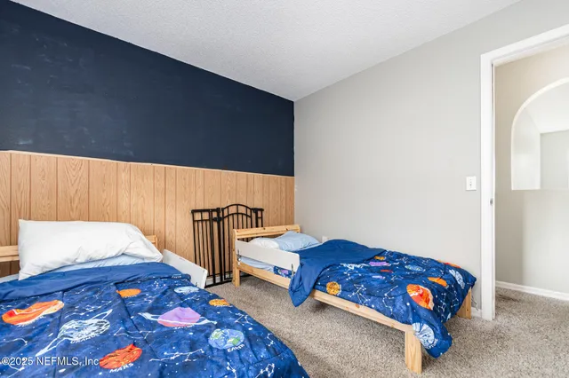 a bedroom with two beds and a lamp