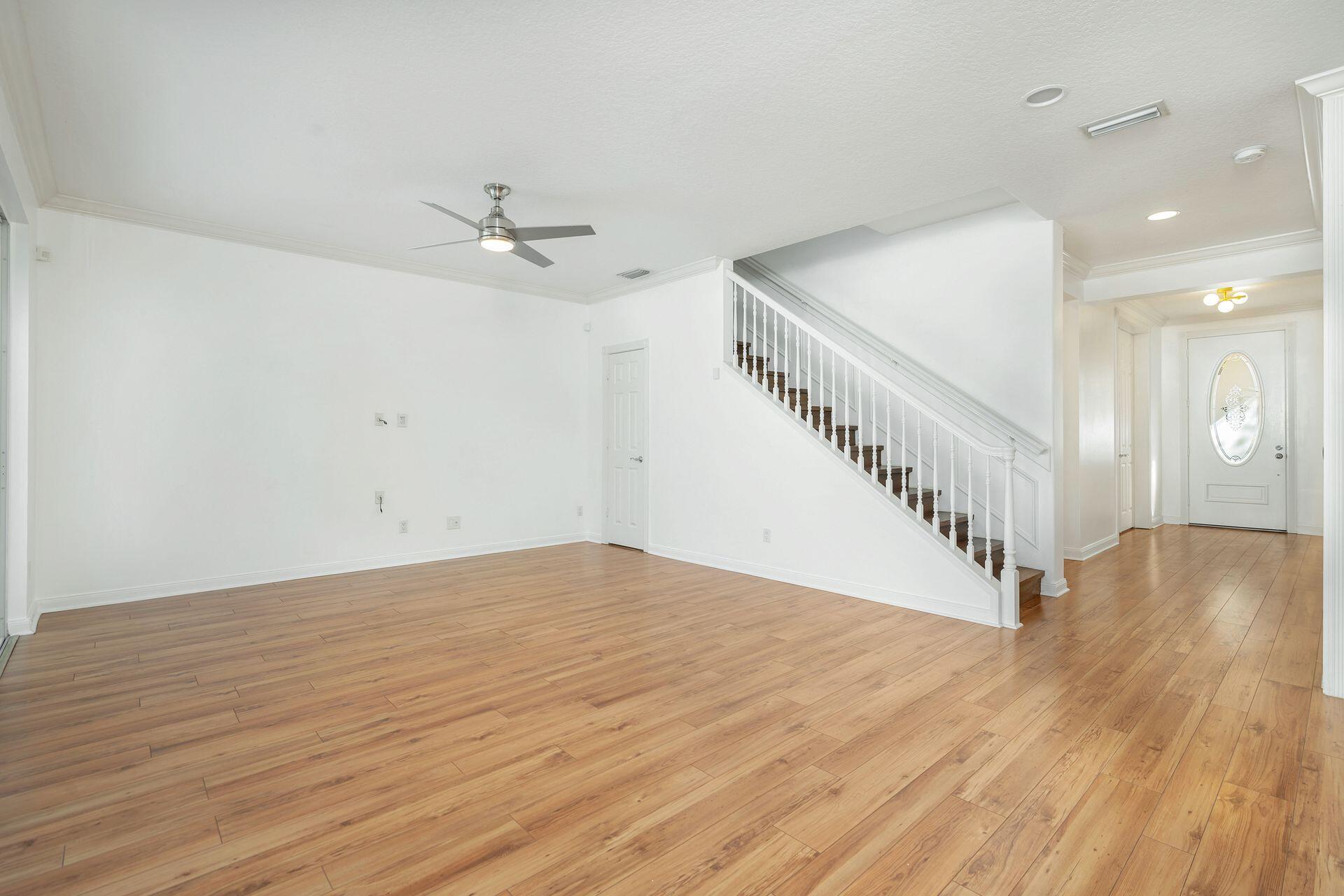 214 New Haven Boulevard Jupiter, FL 33458 - Photo 13 of 40 a view of an empty room with wooden floor and a ceiling fan