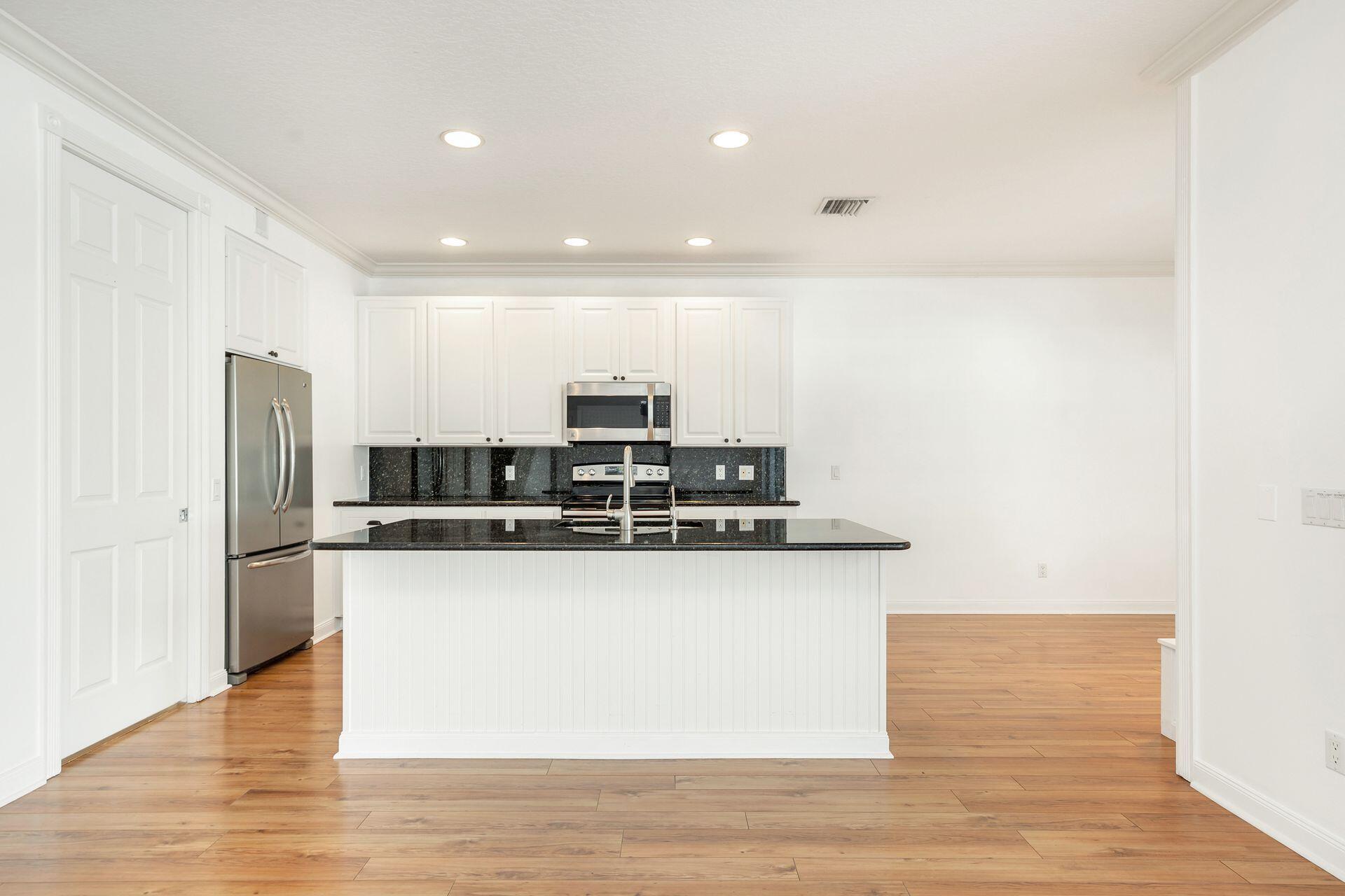 214 New Haven Boulevard Jupiter, FL 33458 - Photo 15 of 40 a kitchen with stainless steel appliances granite countertop a refrigerator and a stove