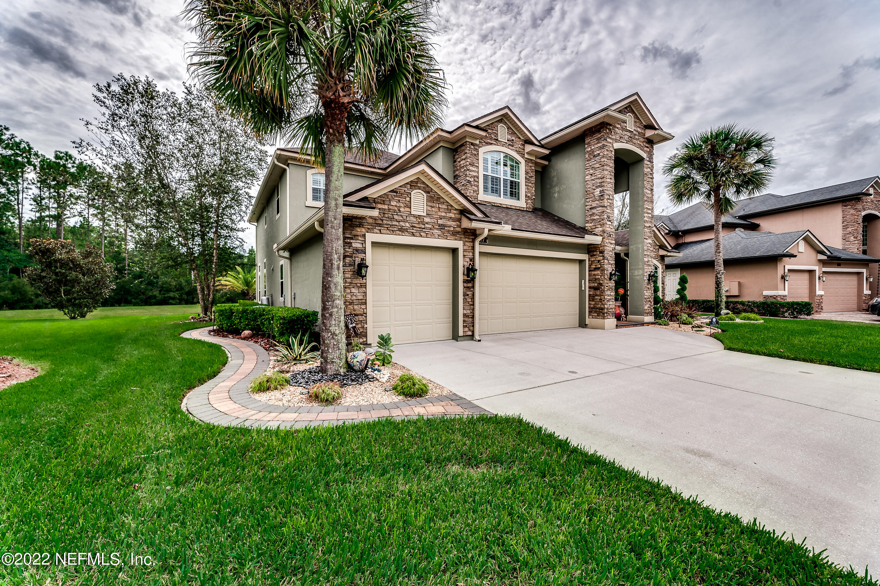 571 Saddlestone Drive Jacksonville, FL 32259 - Photo 4 of 65 a white house with a small yard and large trees