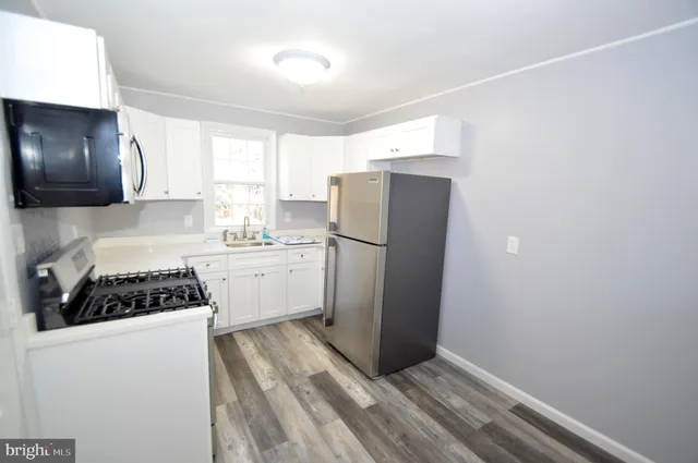 a kitchen with a refrigerator and a stove top oven