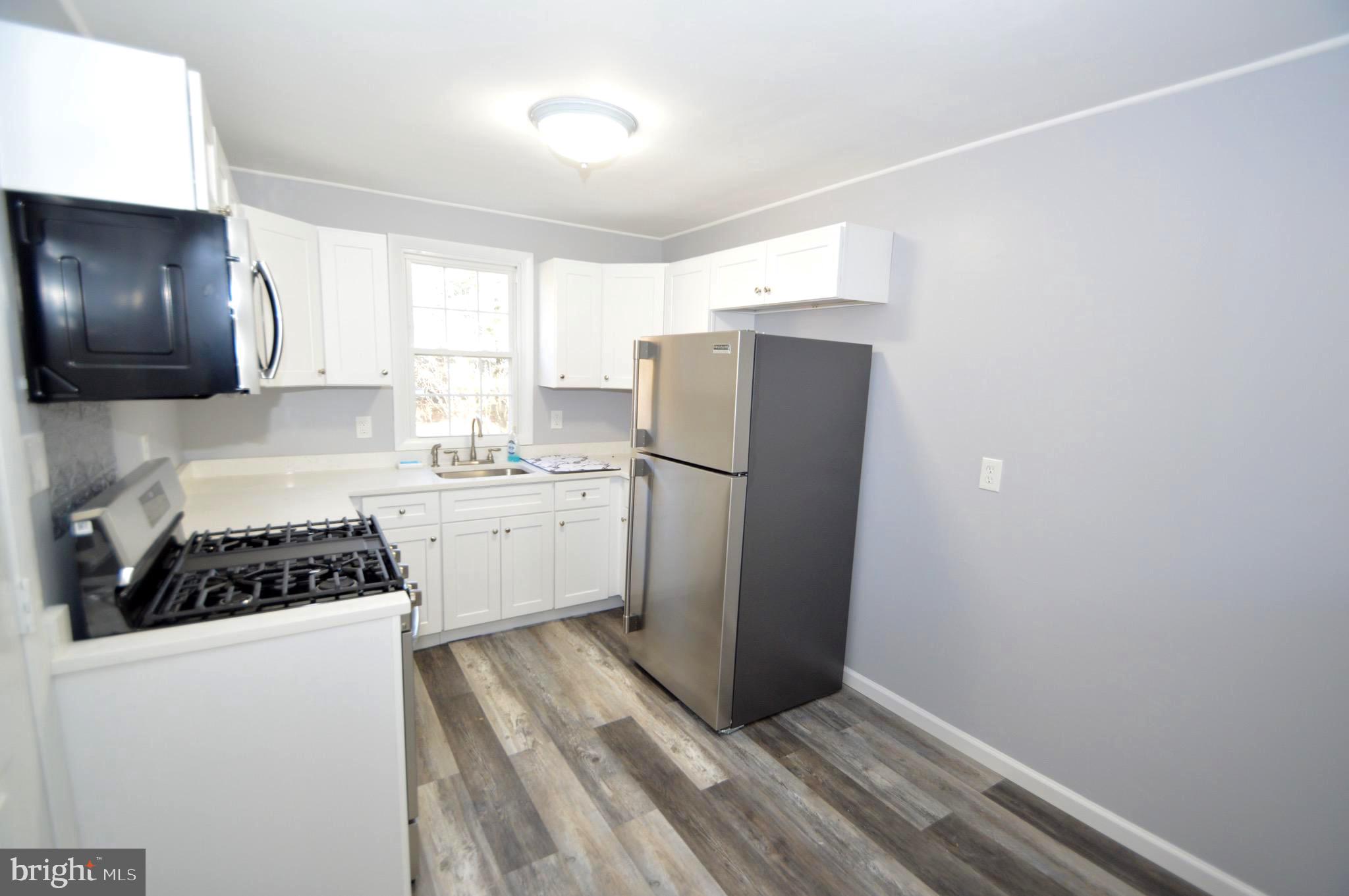 267 Mott Avenue Burlington, NJ 08016 - Photo 6 of 18 a kitchen with a refrigerator and a stove top oven